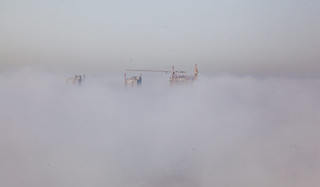 图为2015年12月2日，摄影师在河南滑县供电公司65米高的大楼上拍下城市雾海景观。