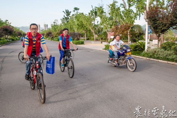 1、6月16日，余庆县都市第三地观光园区，几名骑着自行车的志愿者与骑摩托车的市民并行而过。（王仁磊 摄）.jpg