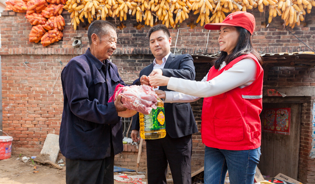 图为10月17日，河南滑县电力小红帽青年志愿者在该县瓦岗乡彭庄，为孤寡老人送去肉和油。