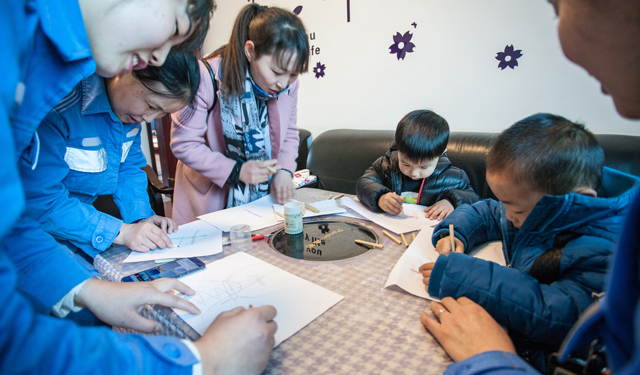 2月14日，活动中，工作人员与职工家属一起带着小朋友画出他们心中的变电站。