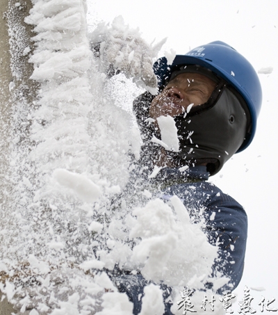 (金辉摄)威宁供电局雪山供电所披毡战队队员正在将电杆上附着冰雪清除保证上杆安全1.jpg
